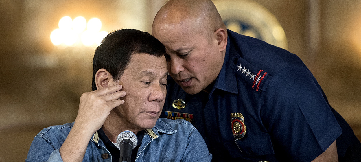 (FILES) This file photo taken on January 30, 2017 shows Philippine President Rodrigo Duterte (L) talking to then Philippine National Police (PNP) director general Ronald Dela Rosa (R) during a press conference at the Malacanang palace in Manila. - Philippines President Rodrigo Duterte said in a pre-recorded speech released late on October 4, 2021 that he will "prepare for my defence" against an International Criminal Court probe into his deadly drug war, after previously insisting he would not cooperate. (Photo by NOEL CELIS / POOL / AFP)